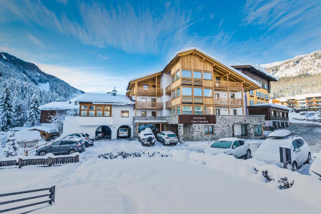 un rifugio per sciatori con auto parcheggiate nella neve di Residence Crazzolara a La Villa