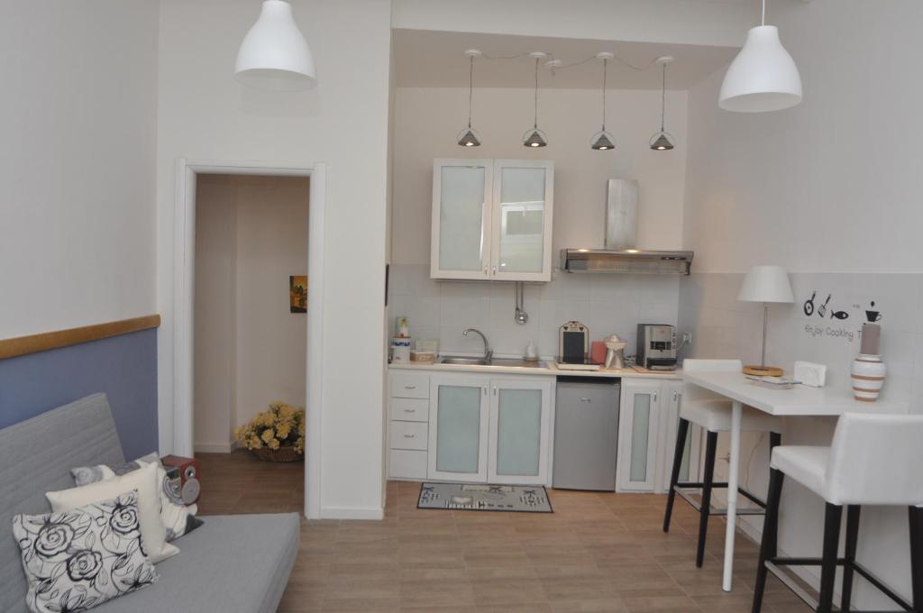 a kitchen with white cabinets and a table in it at Brenta 12 in Messina