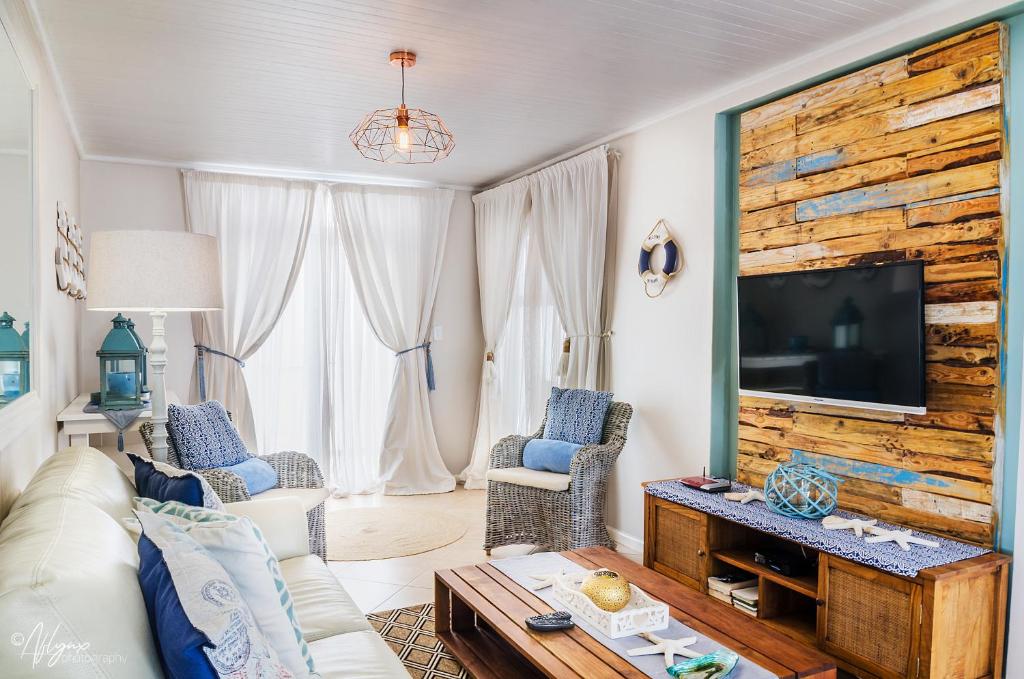 uma sala de estar com um sofá e uma televisão em Mylas Cottage em Swakopmund