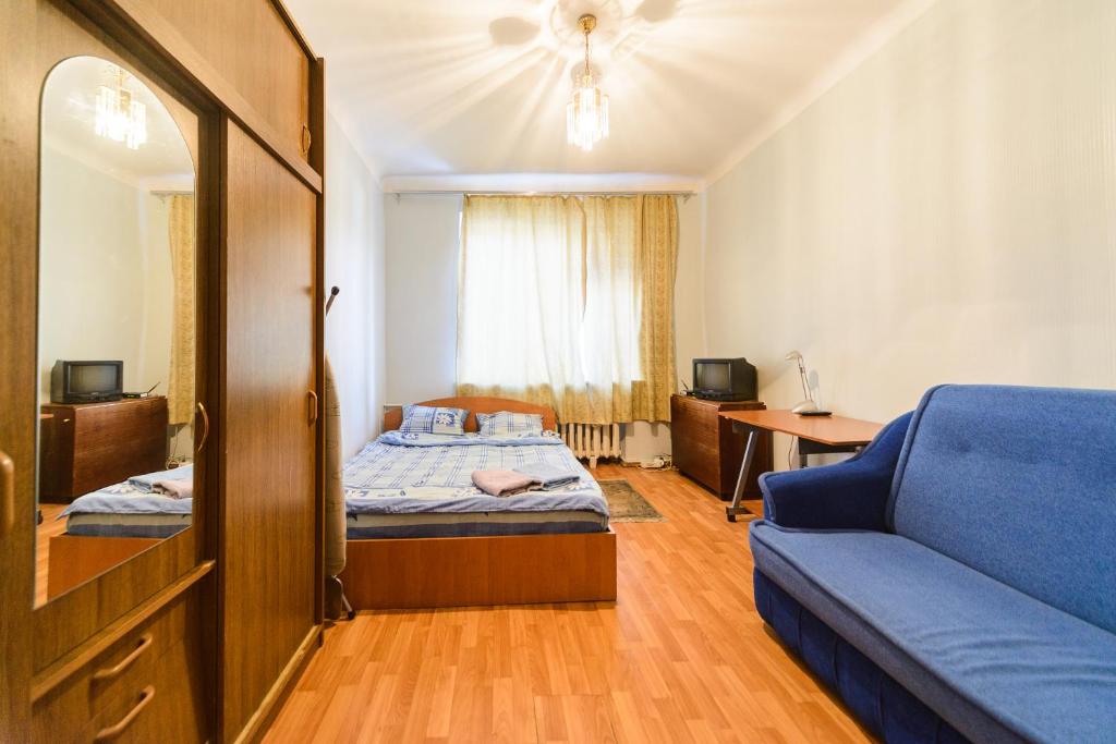 een slaapkamer met een bed en een blauwe bank bij Квартира по адресу ул. Черняховского 12 in Kiev