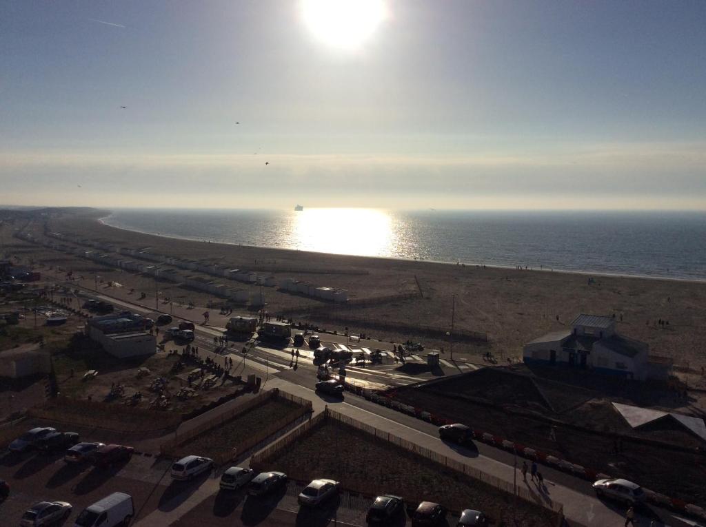 - une vue sur la plage et l'océan avec des voitures dans l'établissement Royal Seavieuw, à Calais
