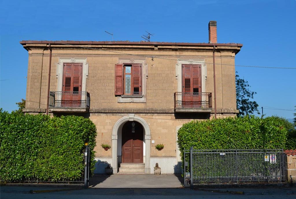 an old brick house with a dog sitting in front of it at Villa Antinea in Avellino