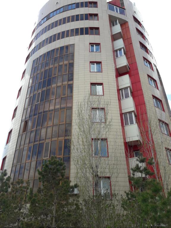 a tall building with trees in front of it at Prospect in Astana