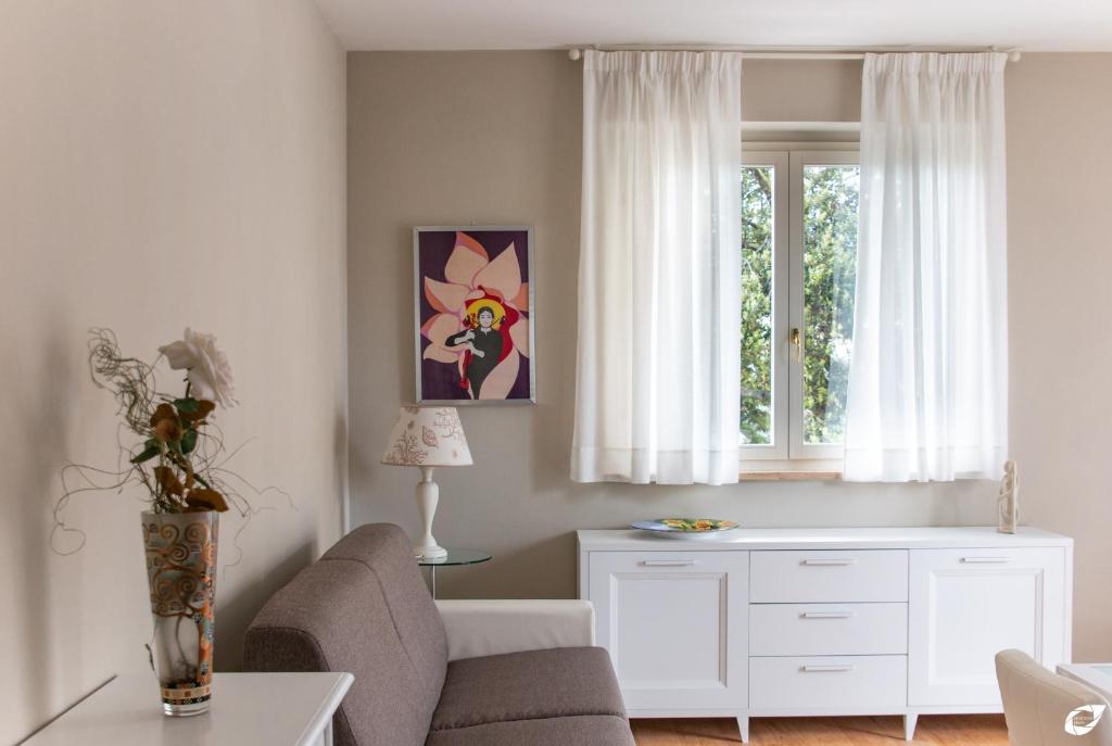 uma sala de estar com um sofá e uma janela em 2-bedroom apt, with balcony & aircondition - 50 m from the beach em Marina di Pietrasanta