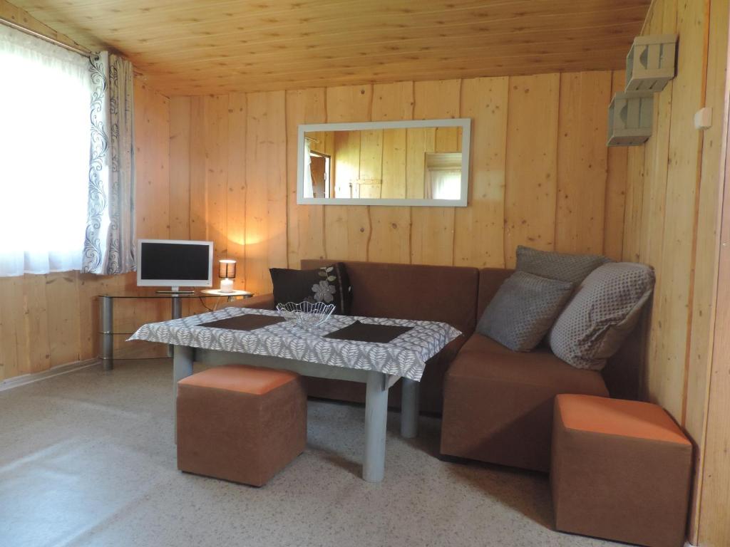 uma sala de estar com um sofá e uma mesa em Mazurskie Wzgórze em Rydzewo