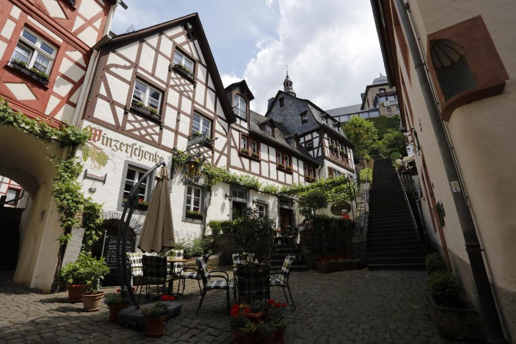 a courtyard of a building with chairs and tables at Winzerschenke in Beilstein
