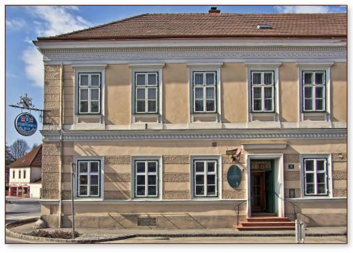 un vieux bâtiment en briques avec une porte dans une rue dans l'établissement Gasthof Manhalter, à Pitten