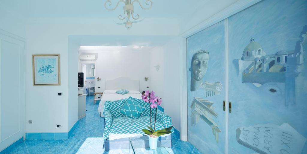 a blue room with a bed and a vase with flowers at Casa Morgano in Capri