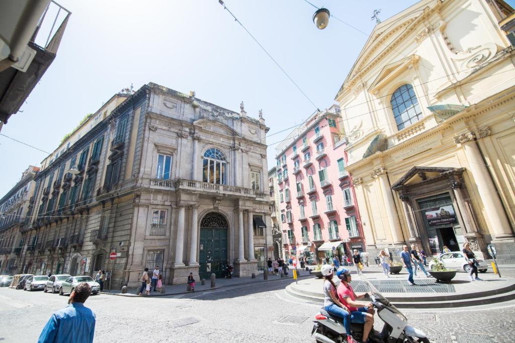 un groupe de personnes voyageant en scooter dans une rue de la ville dans l'établissement Palazzo Doria d'Angri Suites, à Naples