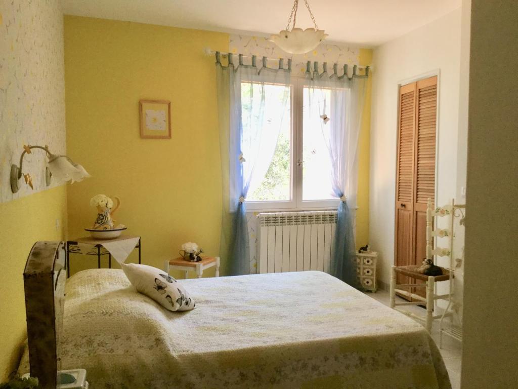 sypialnia z łóżkiem i oknem w obiekcie La Vigne Des Heures Claires w mieście Saint-Nazaire-dʼAude