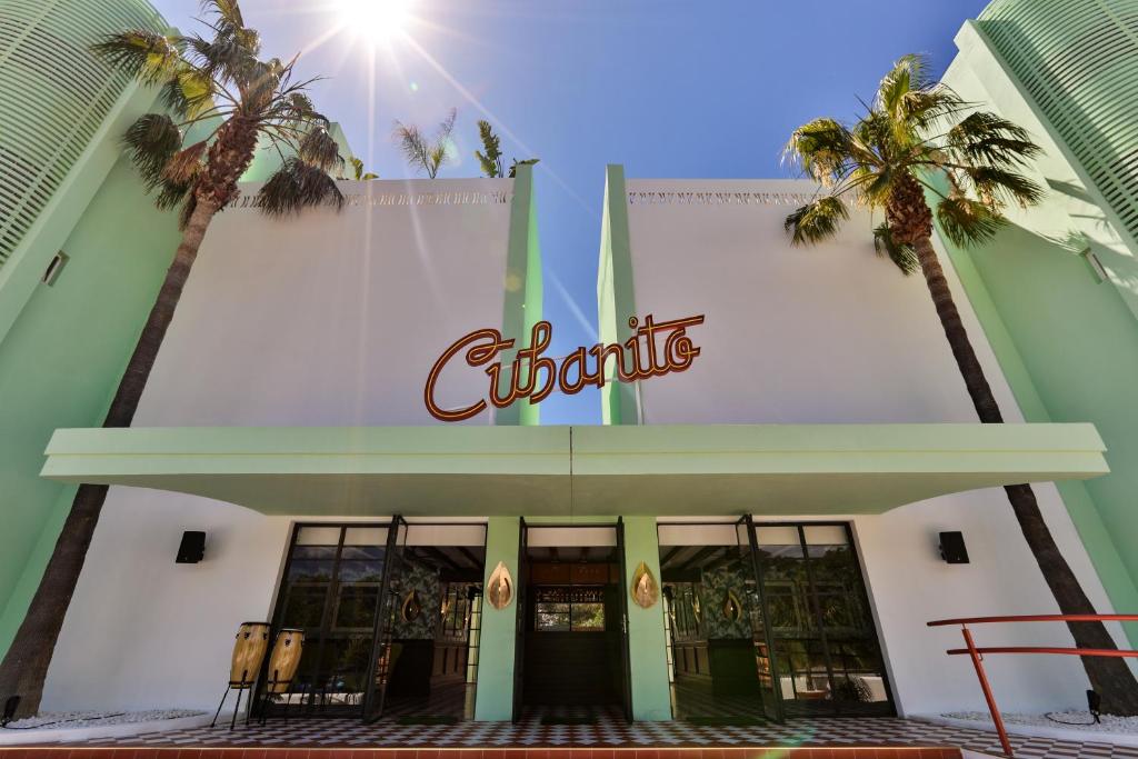 a sign on the side of a building with palm trees at Cubanito Ibiza in San Antonio