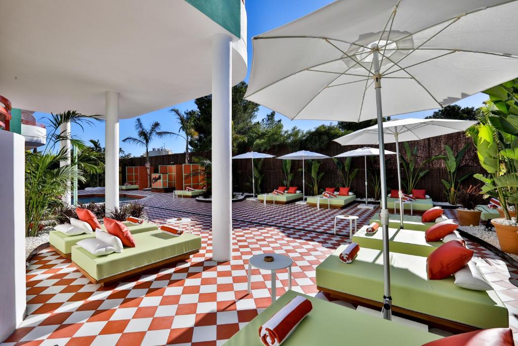 a patio with chairs and umbrellas on a checkered floor at Cubanito Ibiza in San Antonio