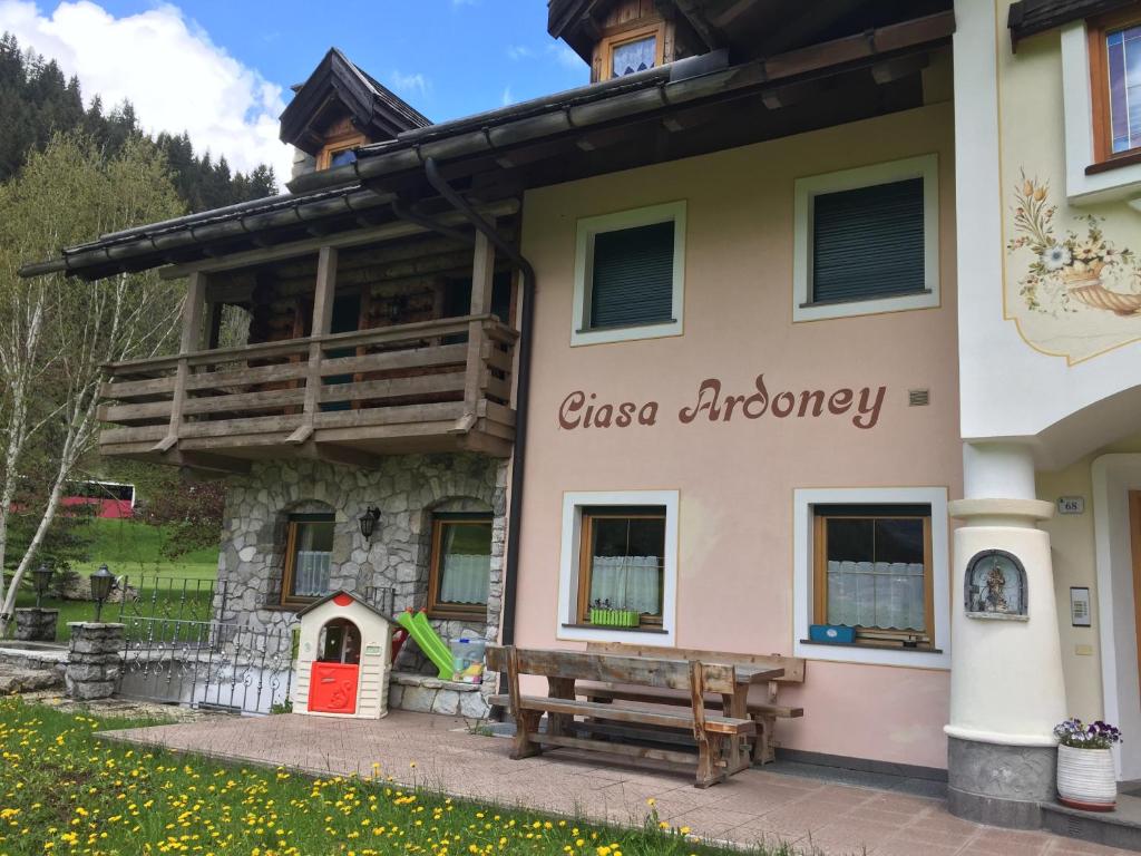 a building with a bench in front of it at Ciasa Ardoney in Campitello di Fassa
