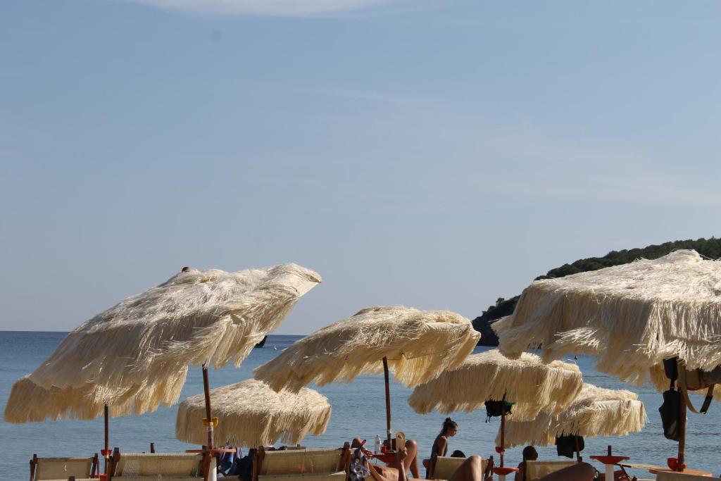 un grupo de sombrillas de paja en una playa en Casa Azzurra 3 camere e 2 bagni en Fetovaia