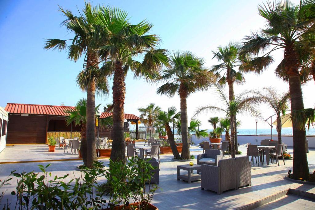 a resort with palm trees and tables and chairs at Villaggio La Bussola in Paola