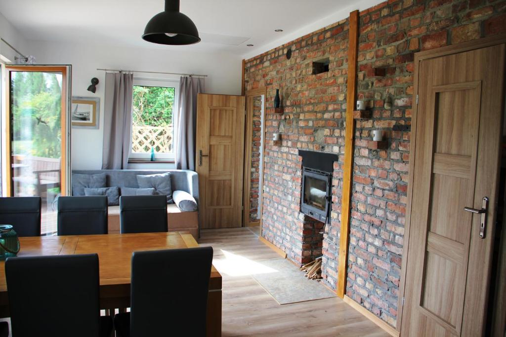 a living room with a brick wall and a table and a fireplace at Dom Morski in Lubiatowo