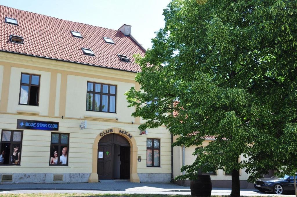 a building with a tree in front of it at Club M.K.M. Modra in Modra