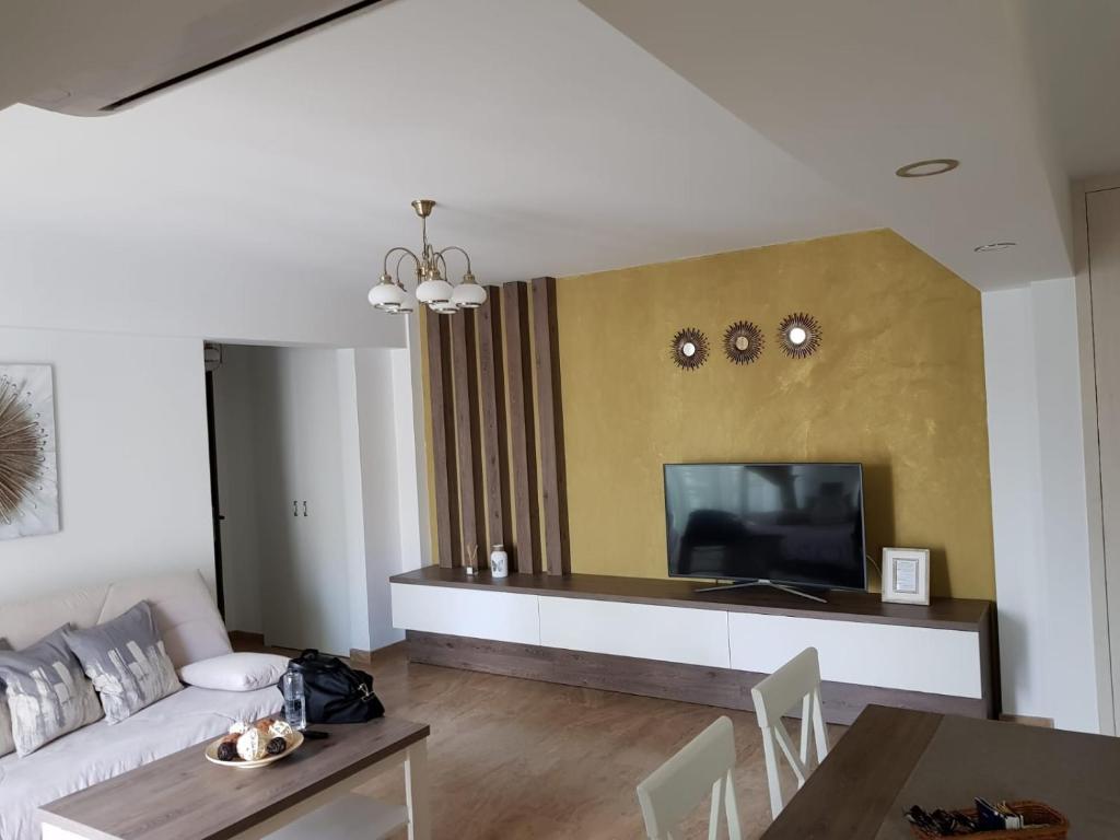 a living room with a couch and a television at apartament 2 camere ultracentral in Râmnicu Vâlcea