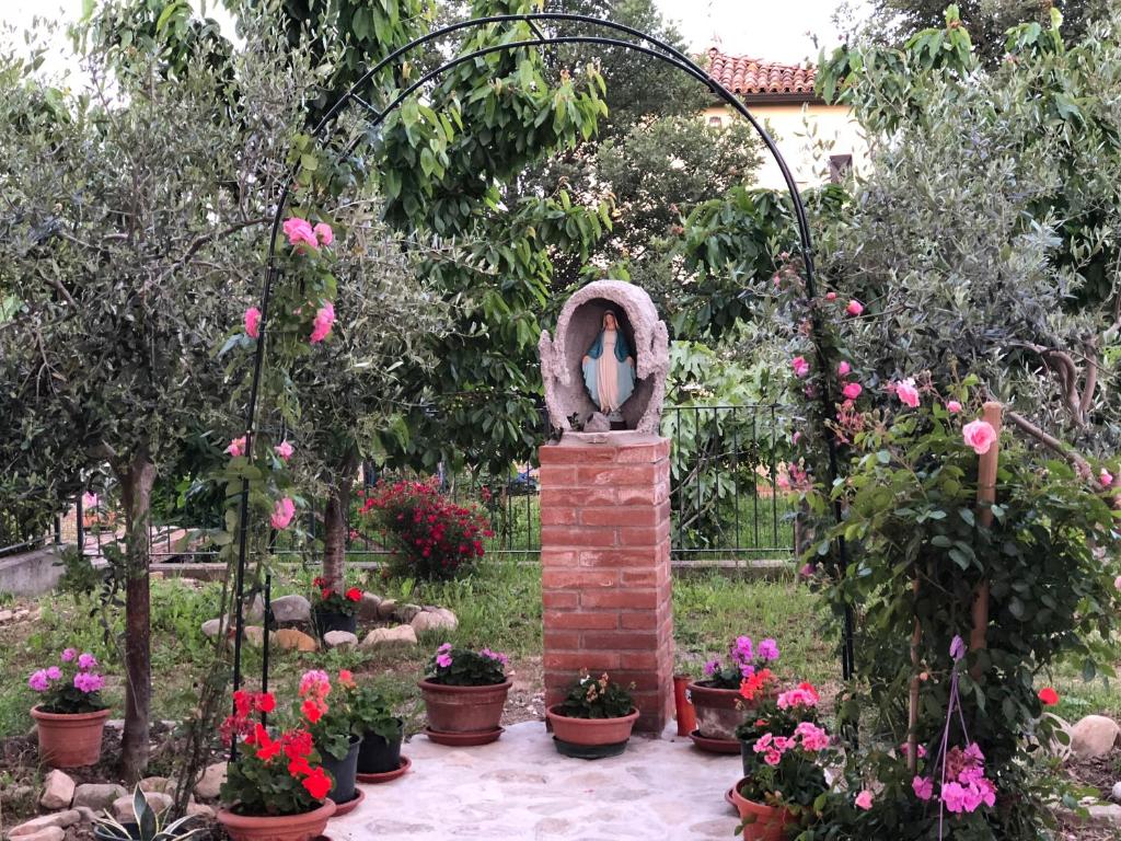 un jardín con un arco de ladrillo y flores en B&B San Giorgio, en Traversetolo