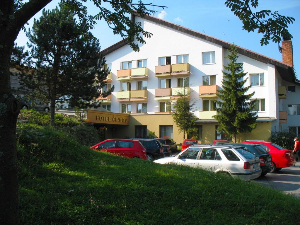 um grande edifício com carros estacionados num parque de estacionamento em Hotel Čingov Slovenský raj em Smizany