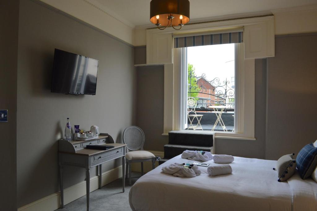 1 dormitorio con cama, escritorio y ventana en The Crown Pub & Guesthouse, en Londres