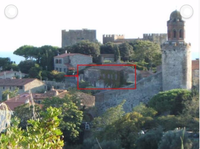 een uitzicht op een stad met een gebouw en bomen bij Casale nel Borgo in Castiglione della Pescaia