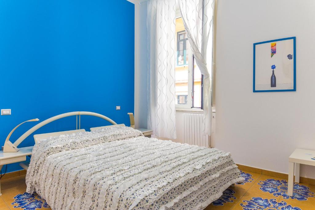 Un dormitorio con una cama y una pared azul. en B&B Le Marinelle, en Salerno