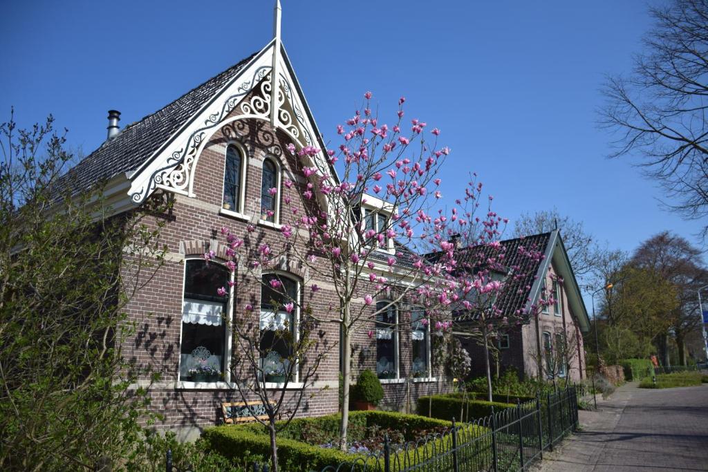 a brick house with pink flowers on it at Het Twiscker Huys in Twisk