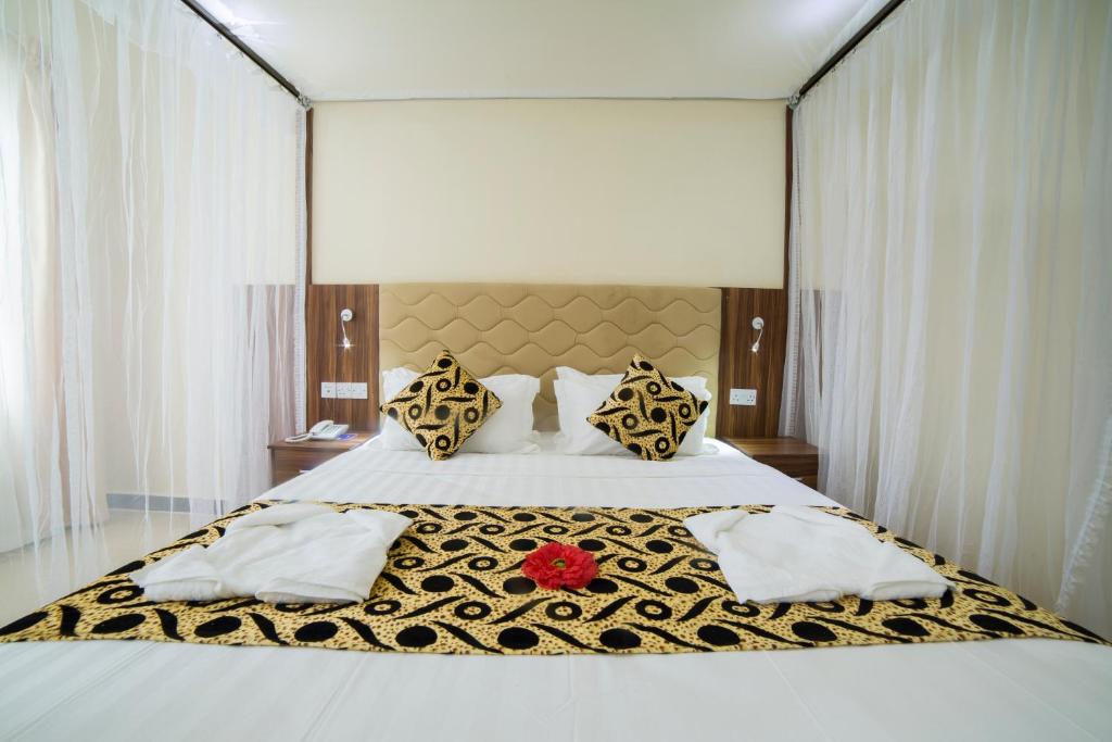 a bedroom with a large bed with a black and white blanket at Spice Palace Hotel in Zanzibar City