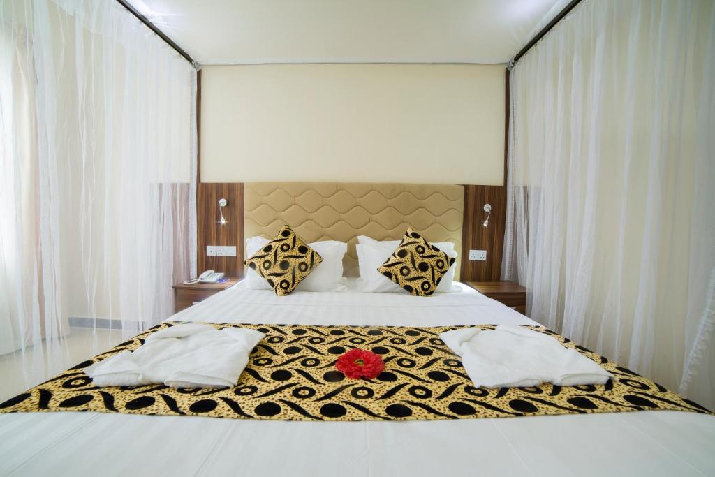 a bed with two pillows and a white comforter at Spice Palace Hotel in Zanzibar City