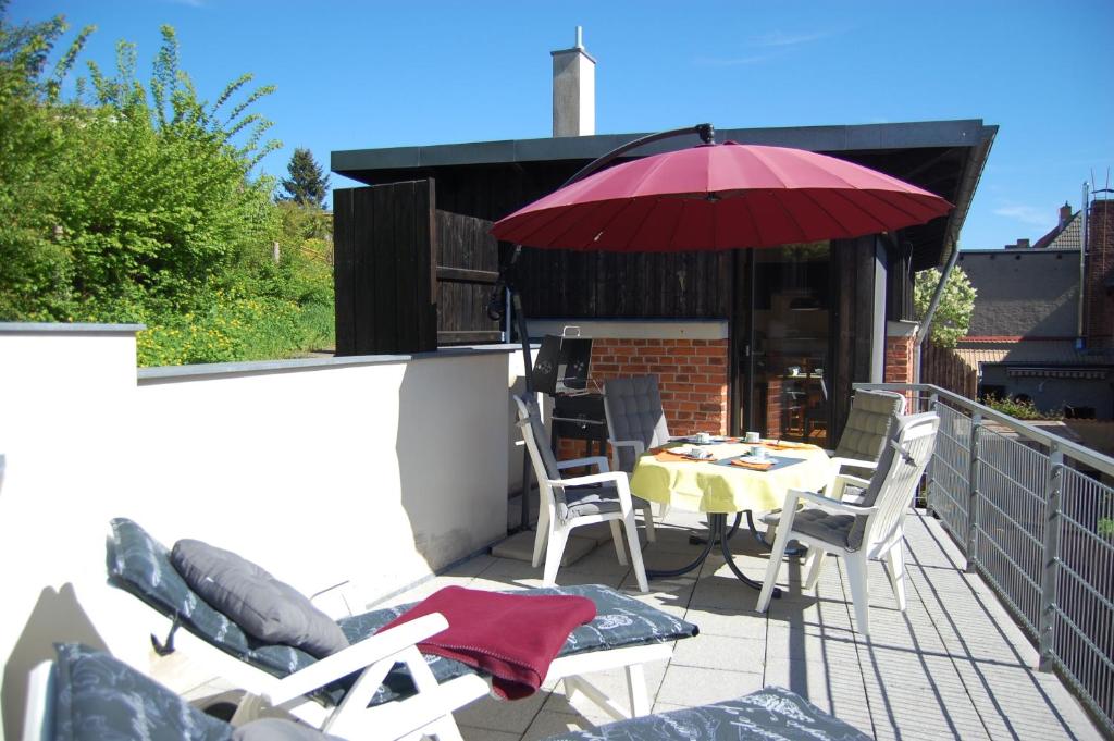 a patio with a table and chairs and an umbrella at Auf dem Berg in Malchow