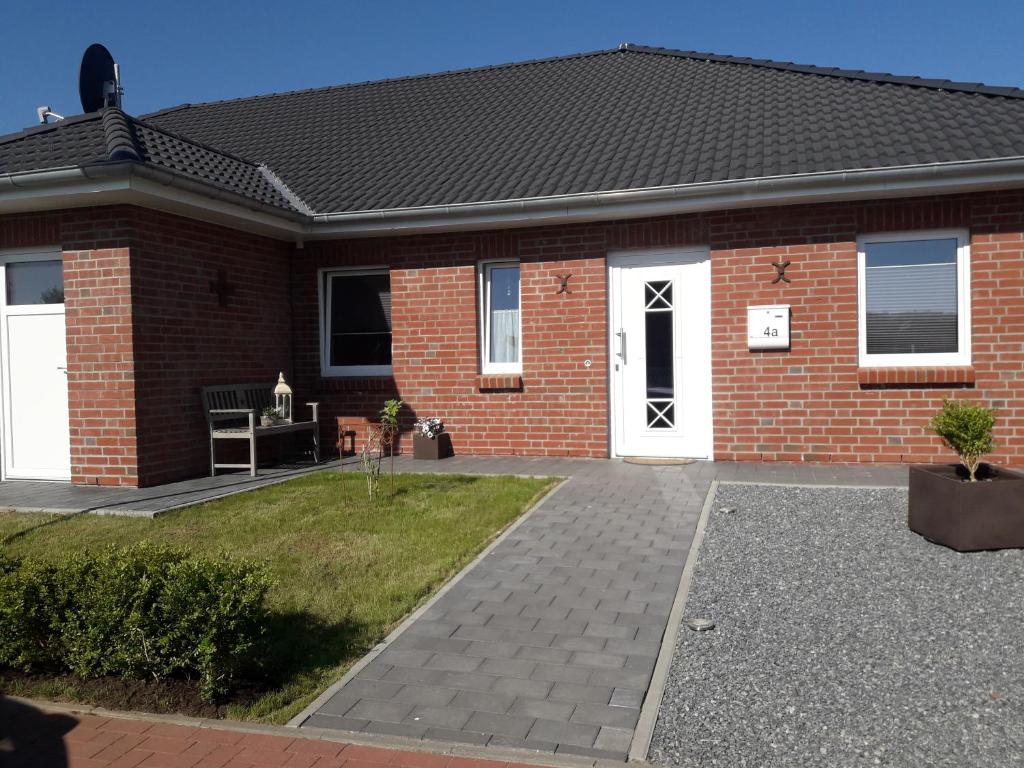 a brick house with white doors and a driveway at Ferienhus Wattkinner in Tönning