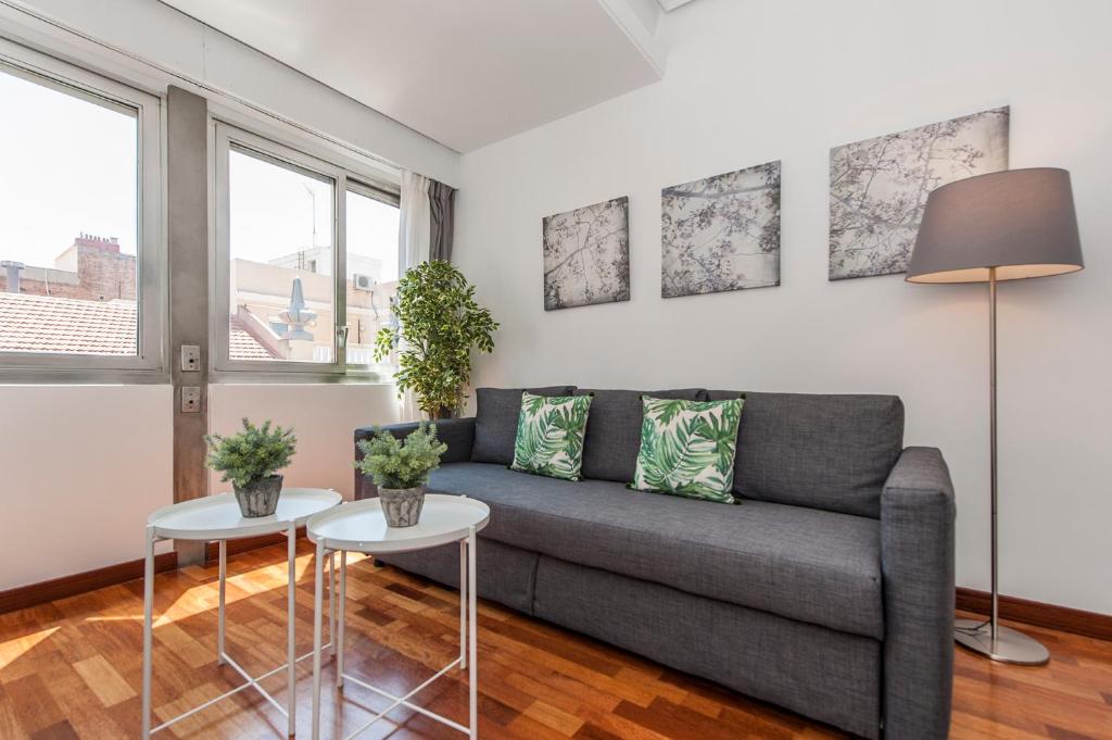 a living room with a couch and two tables at Retiro II in Madrid