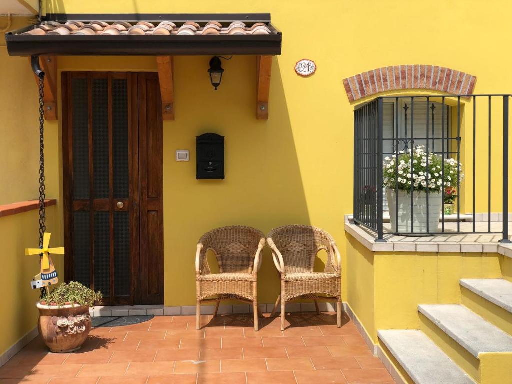 twee rieten stoelen op de veranda van een huis bij Camere e Casa Vacanze in Misano Adriatico