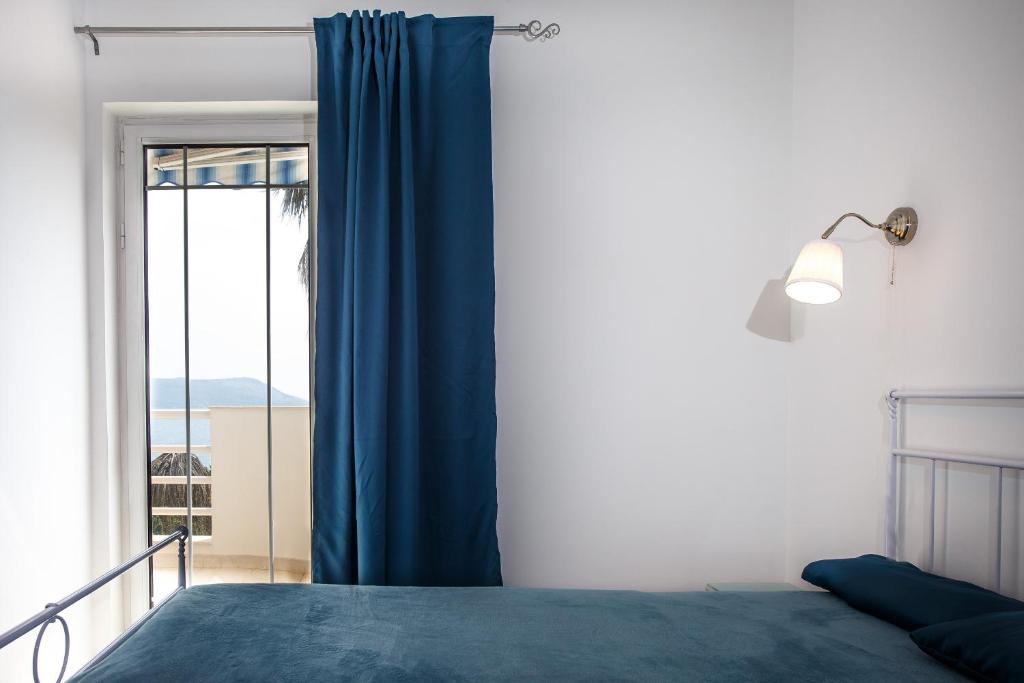 - une chambre avec un lit bleu et une fenêtre dans l'établissement Koi Seaview apartment, à Herceg-Novi