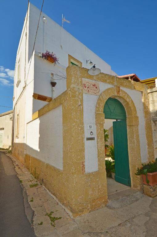 an old building with a green door on a street at Antica Terrazza in Morciano di Leuca