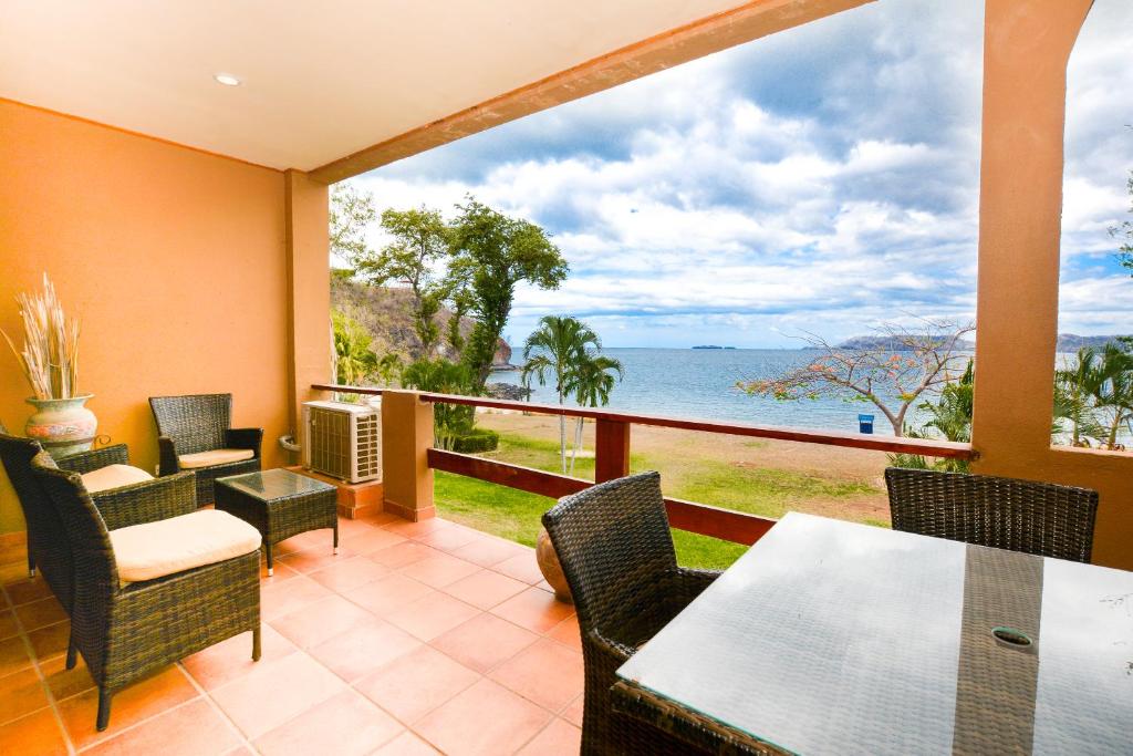 a balcony with a table and chairs and a view of the ocean at Flamingo Marina Resort 612 in Playa Flamingo