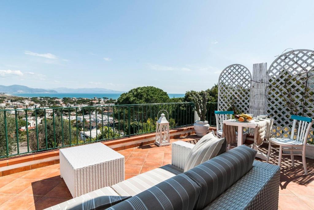 patio con sofá y sillas en el balcón en Macondo B&B en San Felice Circeo