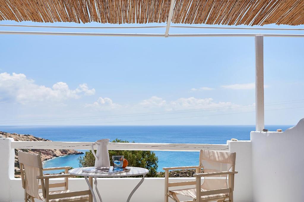 a table and chairs on a balcony with a view of the ocean at Vista Mare Milos in Provatas