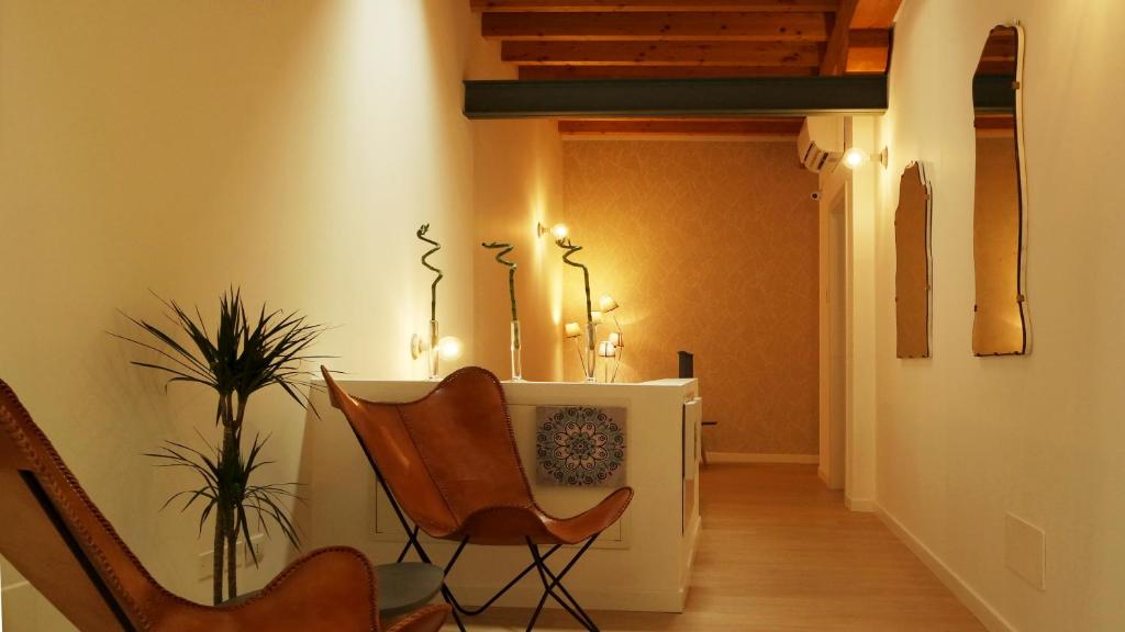 un corridoio con sedie, tavolo e pianta di IndispArte Suites a Bergamo