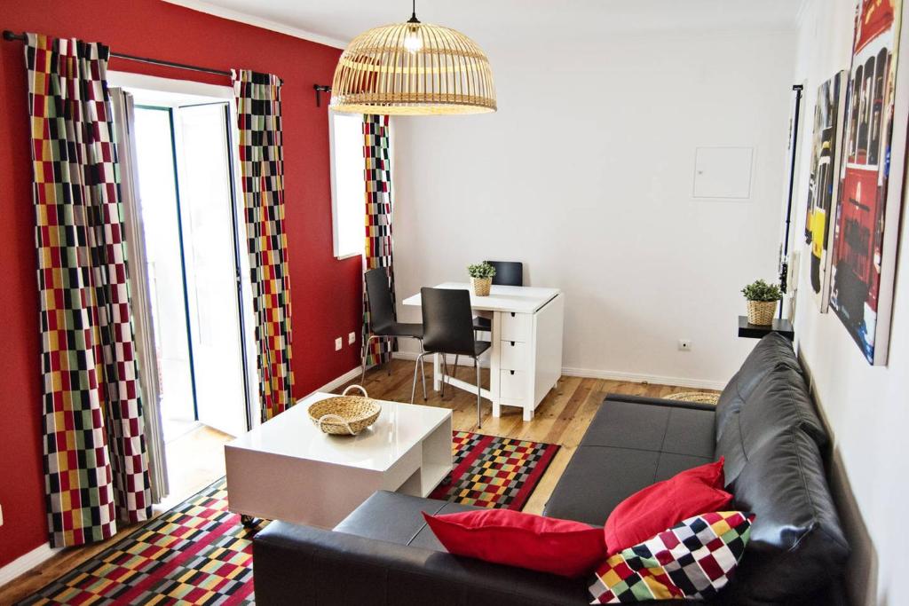 a living room with a black couch and red walls at Fabulous Apartaments in Lisbon
