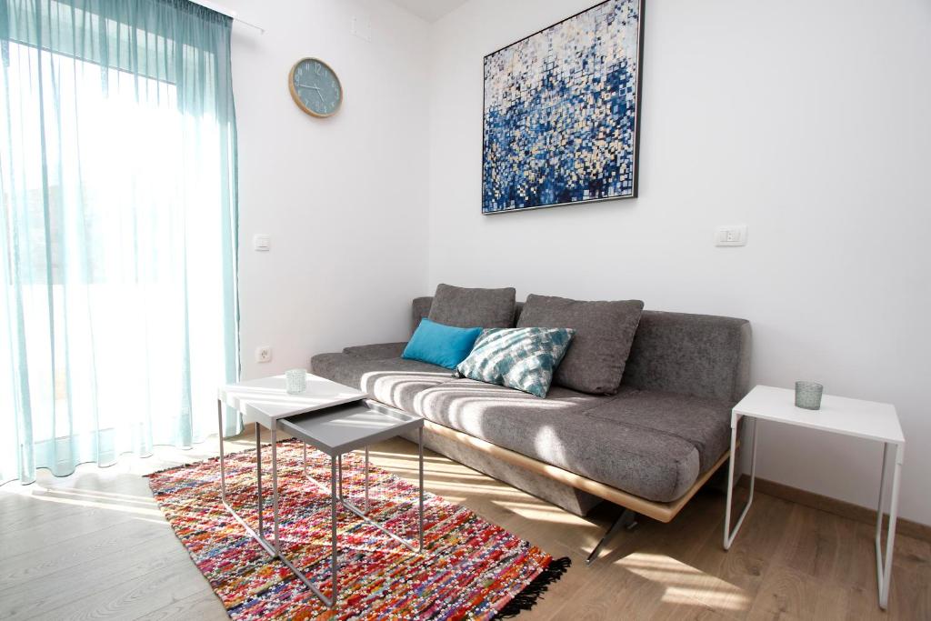 sala de estar con sofá y alfombra en Apartments Besker, en Makarska