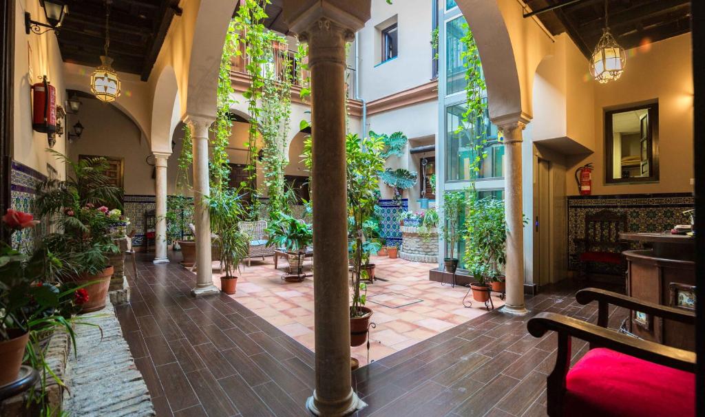 een binnenplaats met potplanten in een gebouw bij Hotel Patio de las Cruces in Sevilla