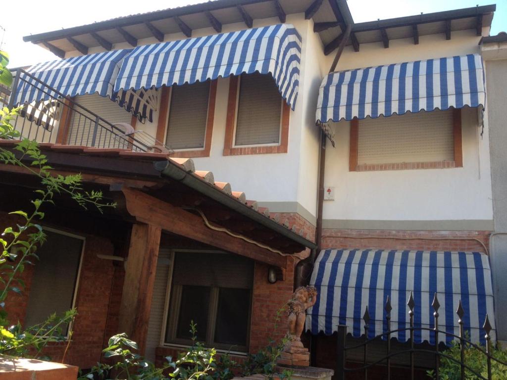 uma casa com toldos azuis e brancos em Casa Viareggio em Viareggio