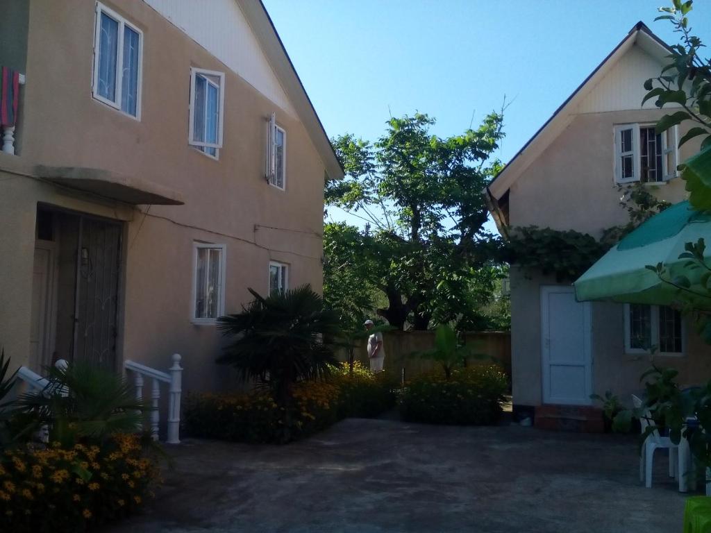 a house with a driveway next to a building at Guest House Giorgi in Ureki