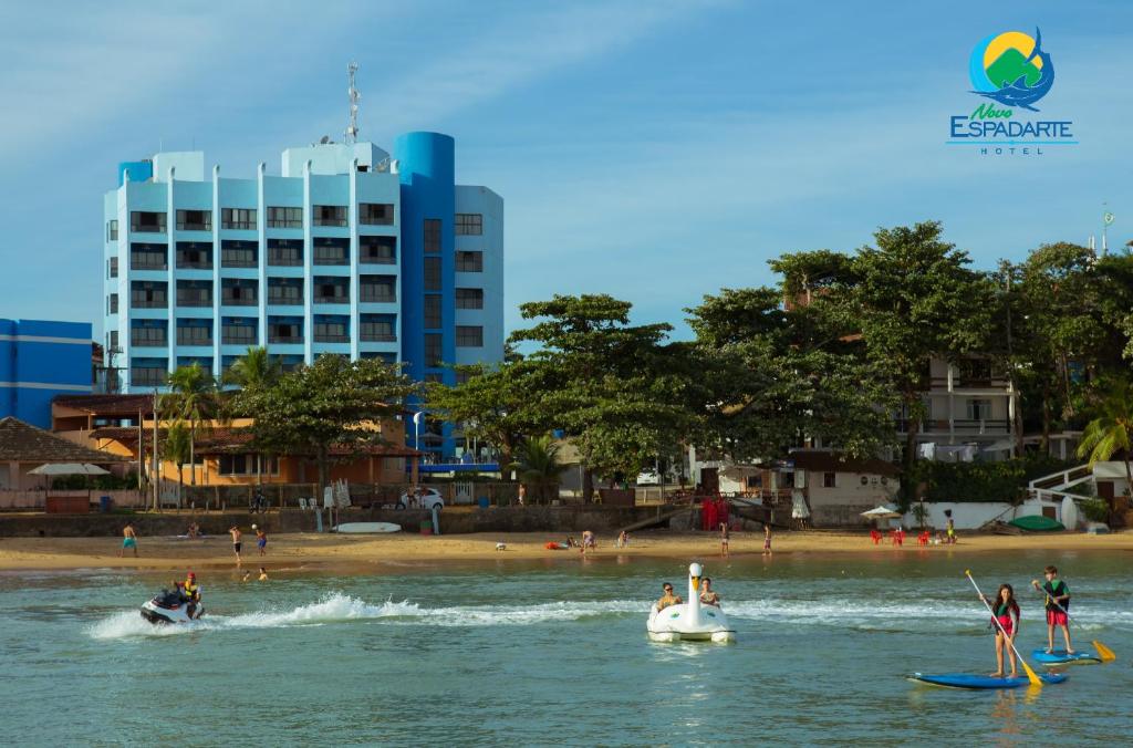 people are on boats in the water near a beach at Hotel Espadarte in Iriri