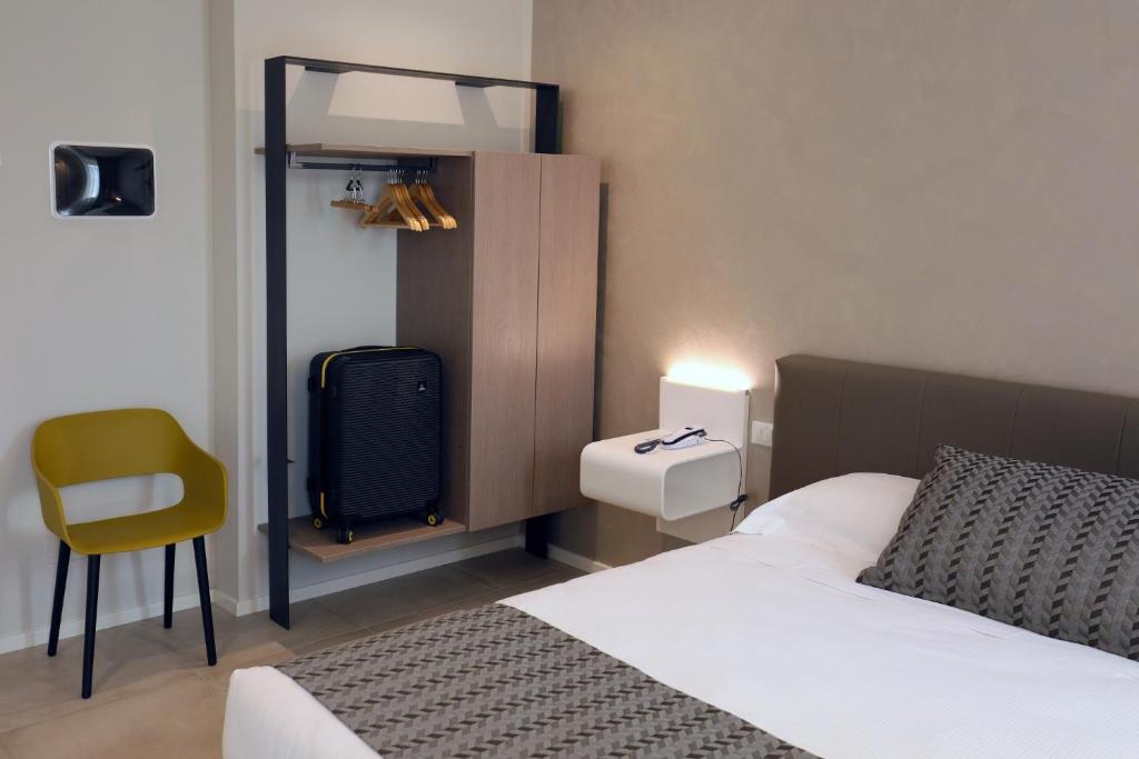 a bedroom with a bed and a chair in it at Hotel Buena Onda in Peschiera del Garda