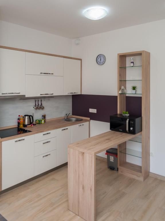 a kitchen with white cabinets and a wooden table at Minka in Kotor