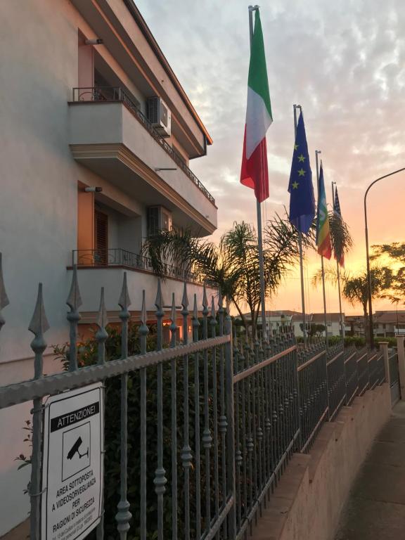 a fence with flags in front of a building at Sunrise Residence in Santa Domenica