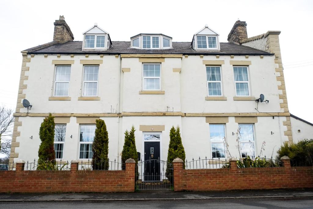 a white house with a fence in front of it at York House Durham in Durham